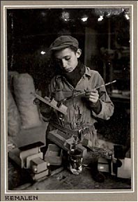 A Jewish boy, coloring toys in a domestic workshop in the Warsaw Ghetto, Poland, around 1941. 